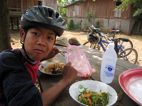 MTB'ing in Northern Laos- Benji sampling the local Buffalo meat in the hill tribe village.